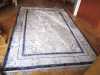 Starší koberec z Číny, prodaný jako hedvábný, asi je to speciálně upravená bavlna. Je 2 x 3 metry veliký, bílý s různými vzory. 